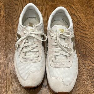 Gold/white New Balance tennis shoes